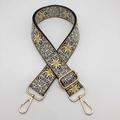 Close-up of ethnic embroidered bag strap with golden metal buckle and lobster clasp - Gold Hook / Black Light Brown White