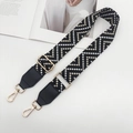 Detail of wide adjustable shoulder strap with geometric wave pattern and gold metal hardware - Gold Hook / Black White Apricot + Black Leather