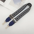Close-up of ethnic geometric jacquard wide strap with blue leather ends and gold metal hooks - Black/Beige/Blue with Blue Leather