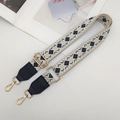 Detail of wide woven strap with geometric diamond patterns and gold metal lobster clasps - Beige/Black with Black Leather