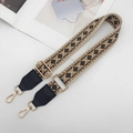 Close-up of ethnic geometric jacquard strap with gold metal hooks and leather trim - Beige/Brown/Black with Black Leather