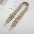 Détail d'une bandoulière tressée kaki avec motifs géométriques et boucles dorées en métal - Abricot + Cuir Abricot
