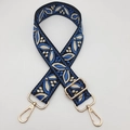 Close-up of ethnic woven guitar-style strap with blue leaf patterns and gold hardware - Black Base Lake Blue