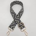 Detail view of woven geometric guitar strap with gold lobster clasps and adjustment buckle - Dark Gray Black / Gold