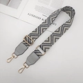 Gros plan sur la bandoulière tissée réglable aux motifs géométriques et crochets dorés - Gris Clair + Cuir Gris