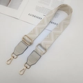 Detail of adjustable woven strap with gold metal buckle and light leather end on white magazine - Gold Hook / Beige + Beige Leather