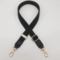 Detail of black woven shoulder strap with gold metal buckles and adjustable slider - Black