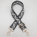 Close-up of adjustable woven bag strap with black and white leaf pattern and gold buckles - Black Base Light Grey White