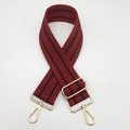 Détail de la sangle de sac tissée rouge et noire avec mousquetons en métal doré clair - Quincaillerie Dorée / Noir et Bourgogne
