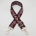 Close-up of wide embroidered guitar-style bag strap with gold metal hooks and floral pattern - Black Wine Red