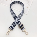 Detail of adjustable embroidered bag strap with navy geometric pattern and gold buckles - Blue & White