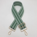 Close-up of ethnic style wide guitar strap for bags with green geometric patterns and gold clips - White Green