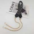 Close-up of woven bag strap with golden chain and black leather details on a magazine - Light Gold Chain / Black