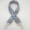 Close-up of beige canvas guitar style strap with blue floral embroidery and gold hooks - Beige Base Lake Blue