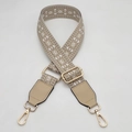 Close-up of geometric patterned fabric bag strap with leather ends and golden metal clips - Apricot White Rice With Apricot Leather