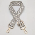 Close-up of wide jacquard bag strap with grey geometric pattern and gold metal hardware - Beige Light Gray