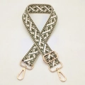 Close-up of jacquard woven strap with green geometric patterns and gold metal hardware - Beige Dark Green