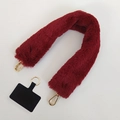 Close-up of plush wine red shoulder strap with golden lobster clasps and phone connector pad - Burgundy