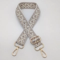 Close-up of jacquard shoulder strap with gold metal buckles and geometric pattern - White With Khaki Dots