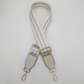 Close-up of adjustable cream woven bag strap with silver glitter stripes and gold hardware - Gold Hook / Cream Silver Thread + Cream Leather