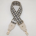 Dettaglio di un'ampia tracolla jacquard geometrica con pelle color crema e ganci dorati - Gancio oro chiaro / Base Beige Nero Bianco + Pelle Beige