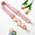 Detailed close-up of pink knitted bag strap with floral accents and gold metal lobster clasps - Gold Buckle / Pink