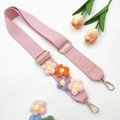 Detailed macro of pink knit bag strap with handmade crochet flowers and gold metal clasps - Gold Buckle / Pink Colored Flower