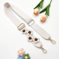 Detailed view of handmade knitted flower strap with golden metal clasp and cream cotton webbing - Gold Buckle / Off White