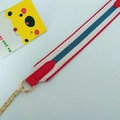 Close-up of tricolor striped webbing strap with red leather ends and gold metal chain - Red Stripes