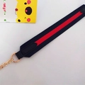 Close-up of classic striped webbing strap with gold metal chain and black leather ends - Blue-Red-Blue