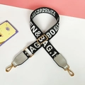 Detail of adjustable nylon shoulder strap with gold hardware and woven fashion letters - Gray