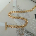 Close-up of golden Cuban chain link accessory with decorative OT clasp on art magazine - Gold Toggle Clasp 80cm