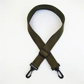 Detalle de correa de lona verde militar con mosquetones de plástico negro y hebilla - Verde