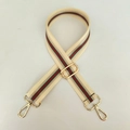 Détail d'une bandoulière rayée réglable en toile avec des mousquetons en métal doré - Beige Avec Boucle Dorée