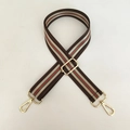 Detail van verstelbare nylon tasriem met groen-rode strepen en gouden metalen haken - Koffie Met Gouden Gesp