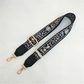 Detailed view of bohemian floral print bag strap with adjustable gold buckle and swivel hooks - Floral Print Black + Black