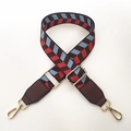Close-up of colorful ethnic geometric pattern wide strap with gold metal lobster clasp - Brown