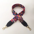 Dettaglio ravvicinato della tracolla in stile boho con moschettoni dorati - Colorato + Nero