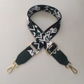 Close-up of geometric woven bag strap with green faux leather ends and gold hardware - Green + Green