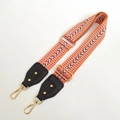 Detail eines verstellbaren orangefarbenen Taschenriemens mit Chevron-Stickerei und Goldhaken - Orange Schwarz
