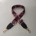 Macro detail of adjustable woven bag strap with red heart pattern and gold metal hooks - Fancy Color + Black