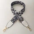 Close-up of geometric ethnic pattern bag strap with gold metal hooks and leather ends - White Tiger + White