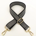 Detail van de verstelbare zwart-witte nylon schouderriem met gouden karabijnsluiting - Zilveren Lijn Pijl
