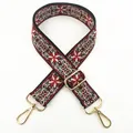 Dettaglio della tracolla bohémien bordeaux con jacquard floreale e ganci in metallo dorato - Borgogna