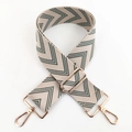 Dettaglio della tracolla beige regolabile con motivo chevron e ganci in metallo dorato - Verde