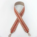 Detail of wide woven strap with orange and blue zigzag pattern and gold metal clips - Orange