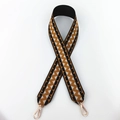 Close-up of ethnic geometric pattern woven strap with gold metal lobster clasps - Black with Yellow Floral