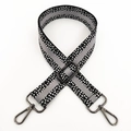 Close-up of adjustable wide woven bag strap with black white pixel pattern and metal clips - Black Grey Gunmetal Buckle