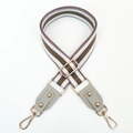 Détail macro de la bandoulière tressée rayée marron et blanc avec boucles dorées champagne - Poudre De Viande + Cendres De Riz