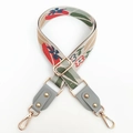 Detailed close-up of floral embroidered bag strap with grey leather ends and gold buckles - Gray
